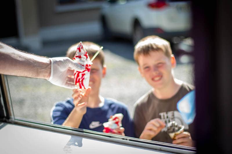 Boy receiving ice cream tub