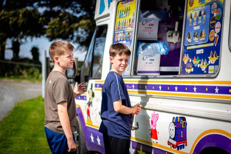 Boy receiving ice cream from ice cream van man