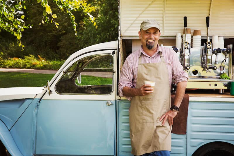 man standing beside vintage ice cream van